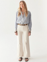 Load image into Gallery viewer, Woman wearing a light blue shirt and beige pants on a white background